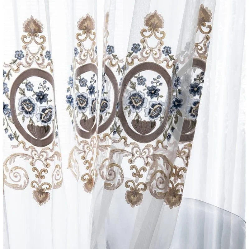 Rideau élégant avec broderies florales bleues et motifs dorés, idéal pour ajouter une touche de sophistication à tout intérieur. Parfait pour habiller les fenêtres du salon ou de la chambre avec style et raffinement.