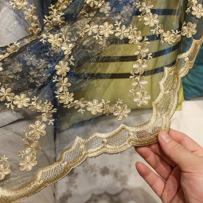 Voile délicatement brodé de motifs floraux dorés sur fond sombre, idéal pour ajouter une touche élégante à votre décoration intérieure. Parfait pour la confection de rideaux ou d'éléments décoratifs, ce tissu apportera sophistication et style à votre espace.