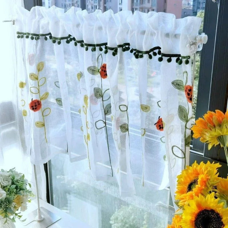 Jolie petite cantonnière blanche à motifs floraux multicolores, idéale pour ajouter une touche lumineuse et printanière à votre cuisine. Décoration élégante avec détails de fleurs brodées et finition pompons. Parfaite pour filtrer délicatement la lumière tout en préservant l'intimité de votre intérieur. Accessoire décoratif apportant une ambiance chaleureuse et accueillante à votre maison. Acheter en ligne cette cantonnière au design délicat pour embellir votre espace