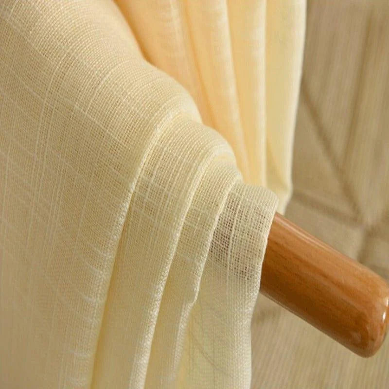 Tissu beige drapé sur une barre en bois, idéal pour confection de vêtements ou décoration intérieure. Texture douce et élégante, parfaite pour ajouter une touche de sophistication à tout espace. Découvrez ce tissu polyvalent pour vos projets créatifs.