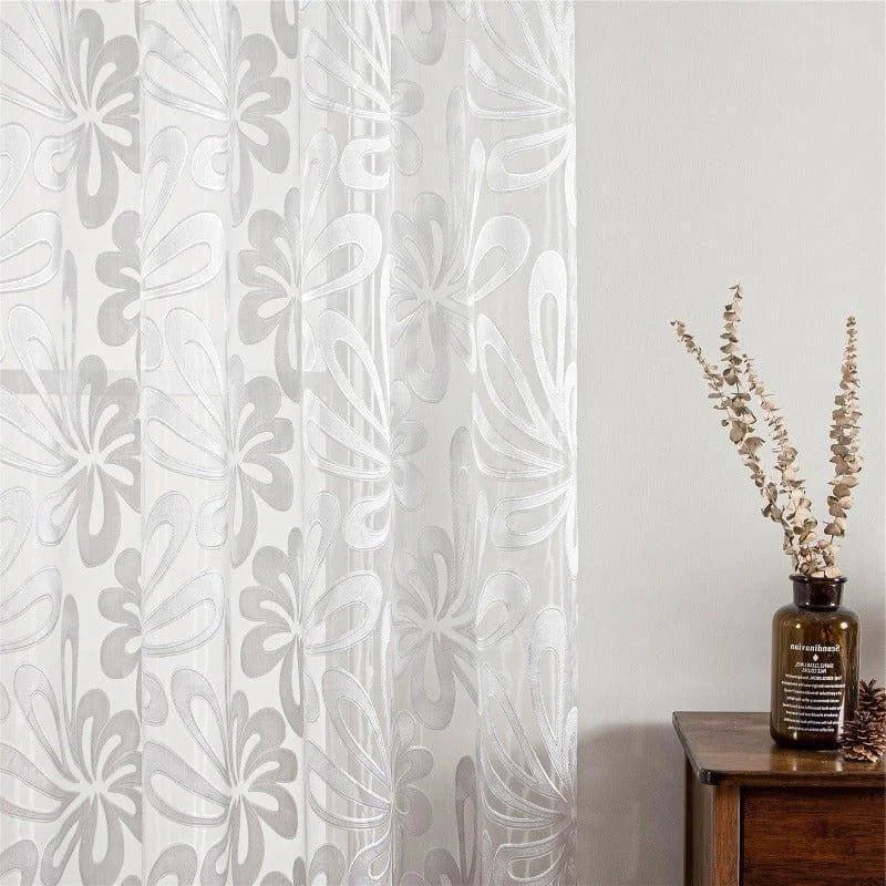 Voilage élégant à motif floral dans un intérieur moderne. Idéal pour ajouter une touche de sophistication et de légèreté à votre décoration. Adapté pour séjour, chambre ou bureau, ce rideau blanc apportera une ambiance apaisante avec sa transparence raffinée. Embellissez vos fenêtres avec ce voilage design et tendance, parfait pour transformer votre espace de vie.