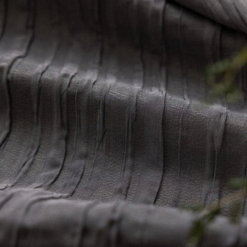 Texture élégante d'un tissu gris foncé avec motifs en relief, parfait pour la décoration d'intérieur ou la confection de vêtements sophistiqués. Découvrez ce design unique et moderne pour apporter une touche d'élégance à votre espace.