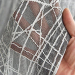 Voile décoratif à motifs géométriques modernes, idéal pour embellir les intérieurs. Texture légère offrant à la fois élégance et originalité. Accessoire parfait pour des projets de décoration raffinée et contemporaine.