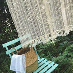 Décoration bohème avec un rideau crocheté élégant, accroché en extérieur. Ambiance naturelle et paisible avec un banc vert pastel et un panier tressé. Idéal pour créer un espace cosy dans votre jardin ou terrasse, apportant une touche d'élégance et de style artisanal à votre décoration extérieure.