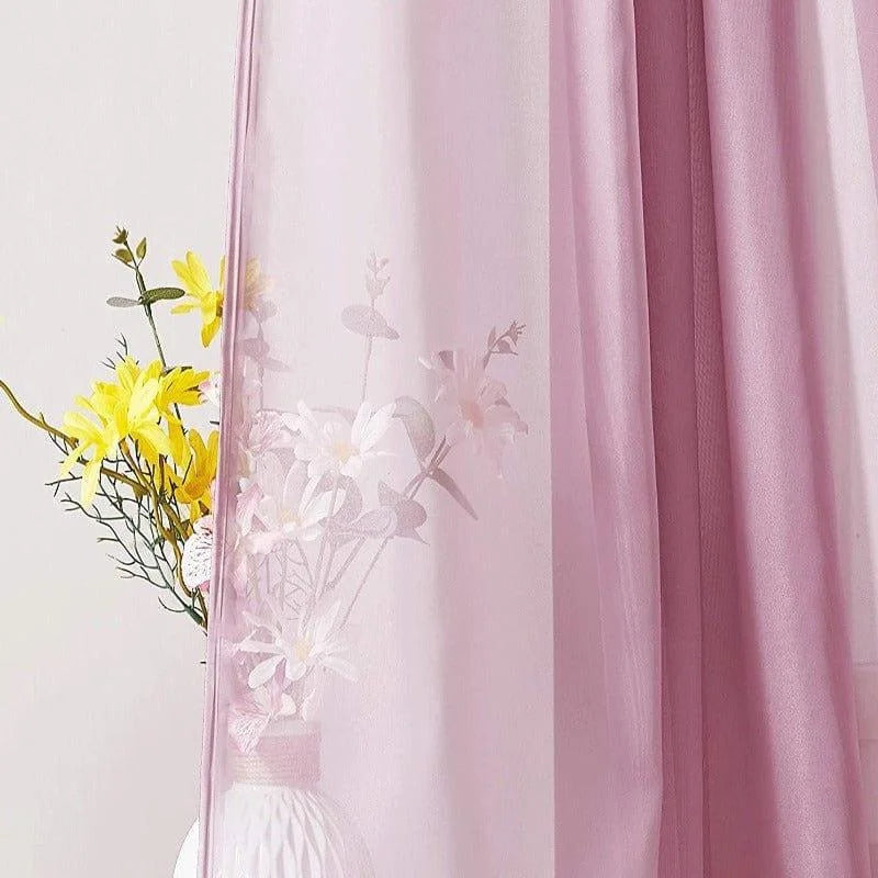Rideau rose transparent avec motif floral, ajoutant une touche élégante à la décoration intérieure. Idéal pour filtrer délicatement la lumière, il crée une ambiance douce et chaleureuse. Parfait pour salon ou chambre, ce rideau orne la fenêtre avec style et subtilité. Accessoire décoratif essentiel, il s'harmonise avec divers intérieurs et apporte une note de fraîcheur grâce à ses motifs de fleurs.
