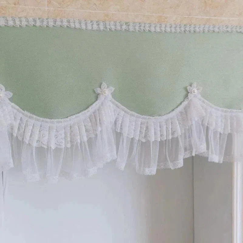 Cantonnière élégante avec détails floraux et plissés blancs, idéale pour apporter une touche de raffinement à n'importe quelle pièce. Cette finition délicate s'intègre parfaitement dans une décoration intérieure romantique et lumineuse, offrant un charme intemporel et élégant à vos fenêtres.