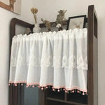 Rideau blanc décoratif avec motif brodé et pompons roses, idéal pour ajouter une touche élégante à votre intérieur. Parfait pour décorer une étagère ou une petite fenêtre, ce voilage s'intègre harmonieusement dans un salon ou une chambre. Créez une ambiance cosy et accueillante avec ce charmant accessoire de décoration.