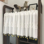 Brise-bise blanc décoratif avec broderies élégantes et pompons colorés en jaune et bleu pour habiller vos fenêtres avec style. Idéal pour ajouter une touche de charme à votre intérieur, tout en préservant votre intimité. Convient parfaitement aux cuisines, salons et chambres à coucher pour une décoration harmonieuse et originale.