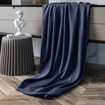 Couverture bleu foncé élégamment drapée, idéale pour ajouter une touche de sophistication à tout intérieur moderne. Parfaite pour apporter chaleur et style à votre salon ou chambre.