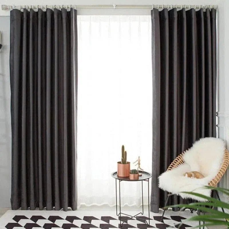 Rideau opaque moderne de couleur sombre avec plis élégants, suspendu dans un salon lumineux. Parfait pour ajouter une touche contemporaine à votre intérieur tout en contrôlant la luminosité. Élément de décoration idéal pour salle de séjour ou chambre à coucher.