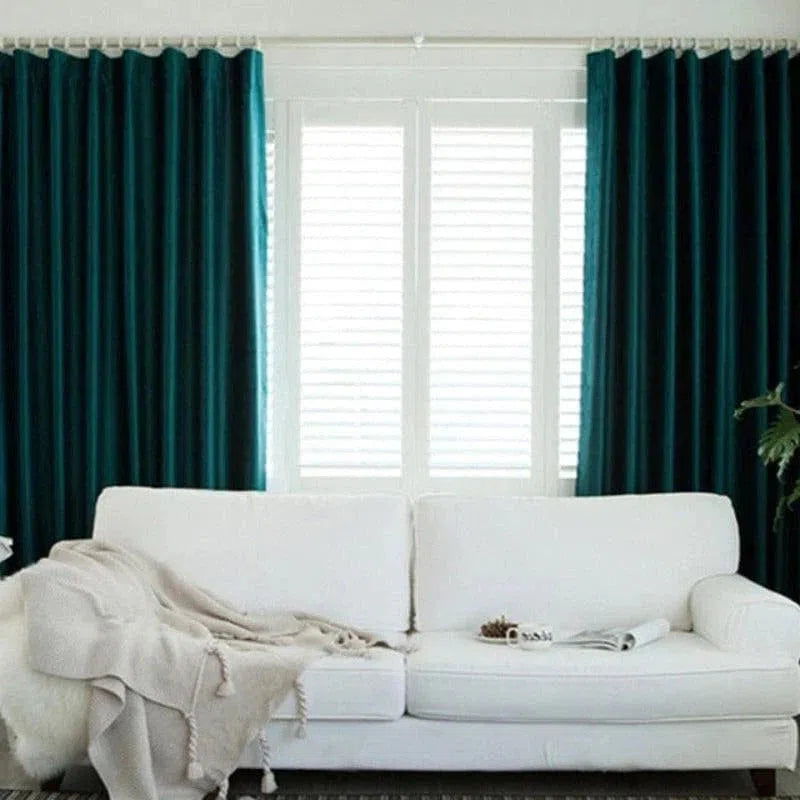 Rideaux verts élégants habillant une fenêtre dans un salon moderne, ajoutant une touche de couleur et de sophistication à l'intérieur. Canapé blanc confortable en premier plan, créant un contraste harmonieux avec les rideaux. Ambiance lumineuse et accueillante.