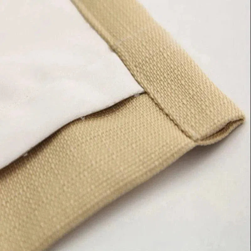 Gros plan sur une housse de protection beige avec bordure soigneusement finie, idéale pour ajouter une touche élégante et discrète à votre intérieur tout en protégeant vos meubles. Design moderne et épuré, parfait pour s'adapter à divers styles de décoration.