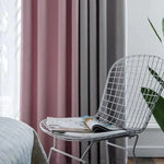 Chaise design avec magazines posée près de rideaux roses et gris, apportant une touche moderne et élégante à la décoration intérieure d'un salon. Découvrez comment créer une ambiance chaleureuse avec un mobilier contemporain et des éléments décoratifs tendance.