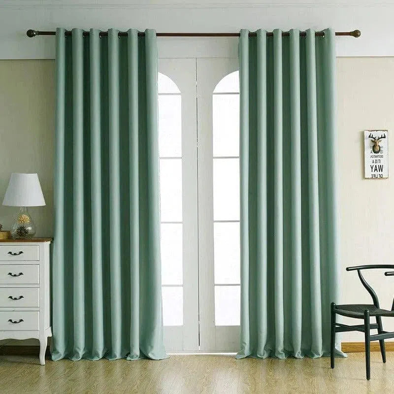 Rideaux élégants de couleur vert clair pour décoration intérieure, installés dans un salon lumineux, complètent élégamment une baie vitrée, apportant une touche moderne et harmonieuse à l'espace. Accessoires parfaits pour personnaliser et rafraîchir votre intérieur avec style.