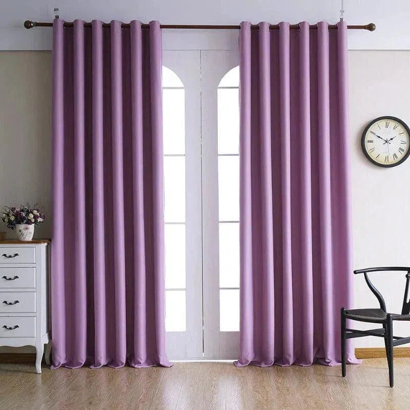 Rideau violet accroché à une tringle dans un salon moderne, avec sol en bois clair et mobilier épuré, idéal pour ajouter une touche élégante et contemporaine à votre décoration intérieure.