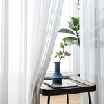 Voilage blanc élégant pour une décoration intérieure raffinée. Profitez d'une ambiance lumineuse et apaisante avec ces rideaux transparents. Idéal pour ajouter une touche moderne à votre salon ou chambre. Complète parfaitement tout style de décoration.