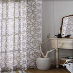 Rideau décoratif à motifs géométriques dans une chambre élégante, associé à une coiffeuse classique et un miroir vintage. Ce design moderne ajoute une touche de sophistication et d'intimité à tout intérieur. Idéal pour embellir votre espace avec style et élégance.