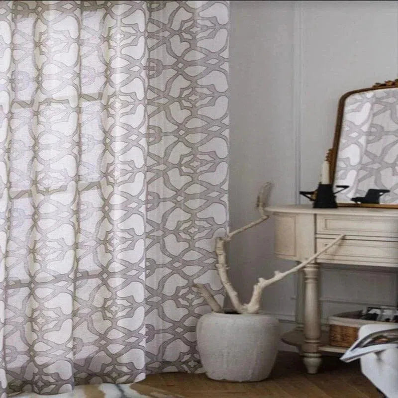 Rideau décoratif à motifs géométriques dans une chambre élégante, associé à une coiffeuse classique et un miroir vintage. Ce design moderne ajoute une touche de sophistication et d'intimité à tout intérieur. Idéal pour embellir votre espace avec style et élégance.