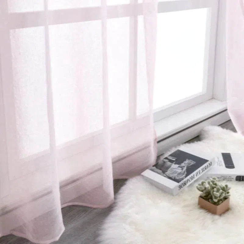 Voilage rose pâle élégant pour fenêtre, ajoutant une touche de douceur et de luminosité à la décoration intérieure. Parfait pour créer une ambiance chaleureuse et accueillante dans le salon ou la chambre. Accessoire idéal pour filtrer subtilement la lumière tout en préservant l'intimité.