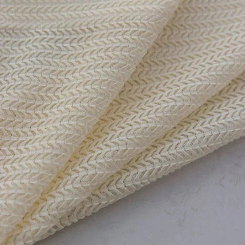 Tissu tricoté beige clair avec motif en chevrons, idéal pour la confection de vêtements confortables et élégants. Texture raffinée apportant une touche sophistiquée à vos créations textiles. Parfait pour des projets de couture modernes et stylés.