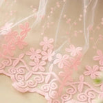Détail délicat d'un tissu décoré de motifs floraux roses. Les fleurs brodées ajoutent une touche élégante et romantique, idéale pour les décorations d'intérieur ou la confection de vêtements raffinés. Parfait pour créer une ambiance douce et féminine dans une chambre ou un salon.