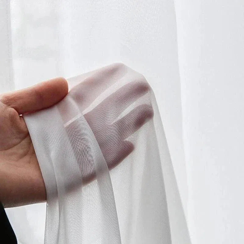Voilage blanc translucide idéal pour illuminer votre intérieur. Ce rideau élégant offre une touche légère et aérienne à n'importe quelle pièce, laissant passer la lumière tout en préservant votre intimité. Parfait pour une décoration moderne et épurée.