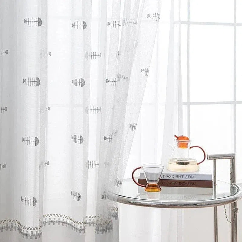 Voilage translucide avec motifs de poisson, parfait pour ajouter une touche marine subtile à votre décoration d'intérieur. Idéal pour illuminer la pièce tout en préservant une ambiance cosy et élégante. Accessoire déco chic pour salon ou chambre, avec une table moderne et une carafe design.