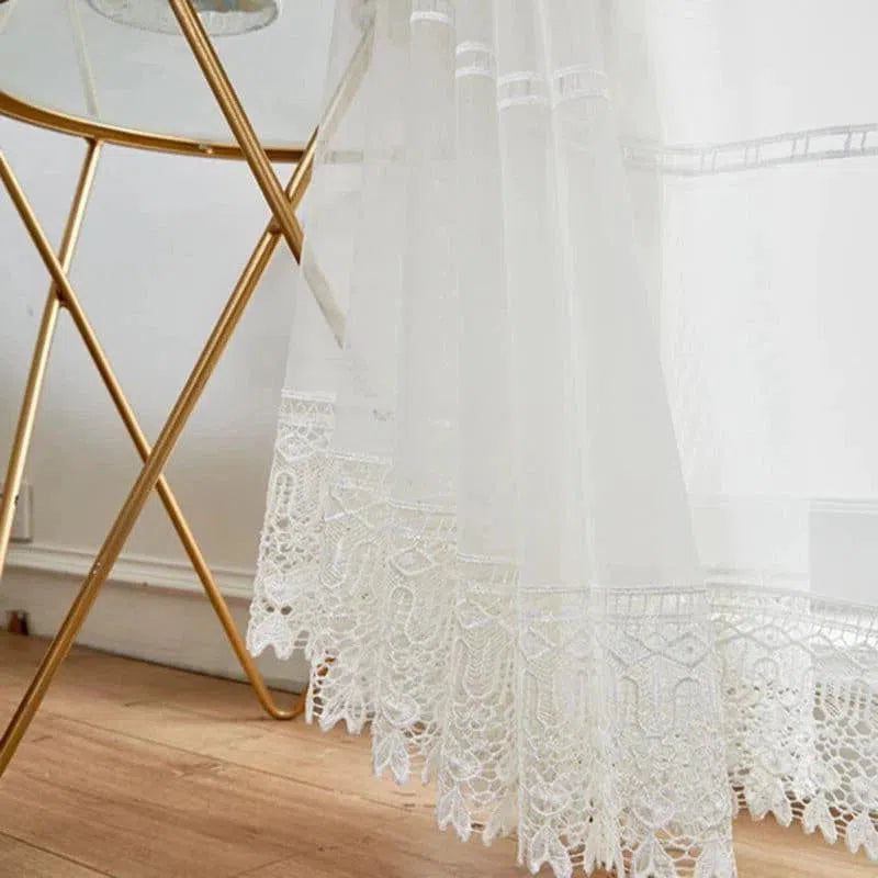Rideau élégant avec dentelles décoratives, parfait pour une touche sophistiquée dans un salon moderne. Ce rideau blanc laisse filtrer la lumière tout en préservant l'intimité de votre intérieur. Idéal pour habiller vos fenêtres avec style.