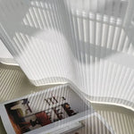 Voilage blanc léger suspendu, créant des jeux d'ombre et de lumière dans une pièce lumineuse. Parfait pour filtrer la lumière naturelle tout en ajoutant une touche esthétique à votre décoration intérieure. Idéal pour un salon moderne ou une chambre calme. Découvrez comment ces rideaux apportent élégance et tranquillité à votre espace.