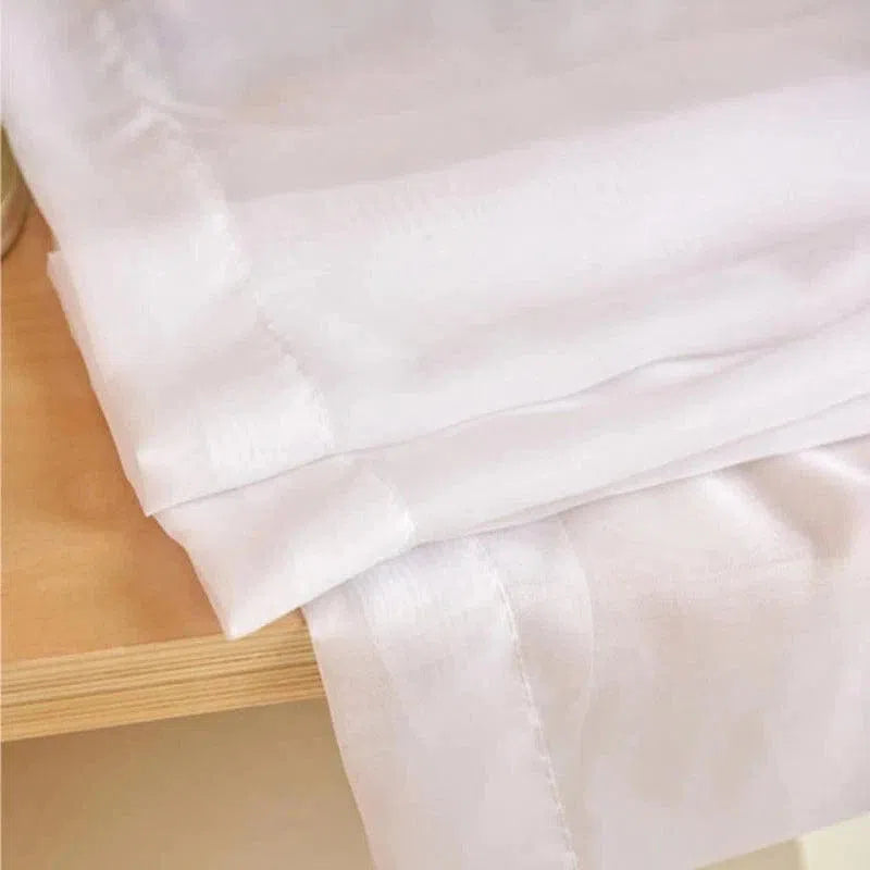 Drap blanc élégant posé sur une surface en bois clair, idéal pour ajouter une touche moderne et épurée à votre décoration intérieure. Sa couleur lumineuse et son design classique s'adaptent à divers styles de chambres, offrant une ambiance apaisante et chic. Parfait pour une maison contemporaine et accueillante.