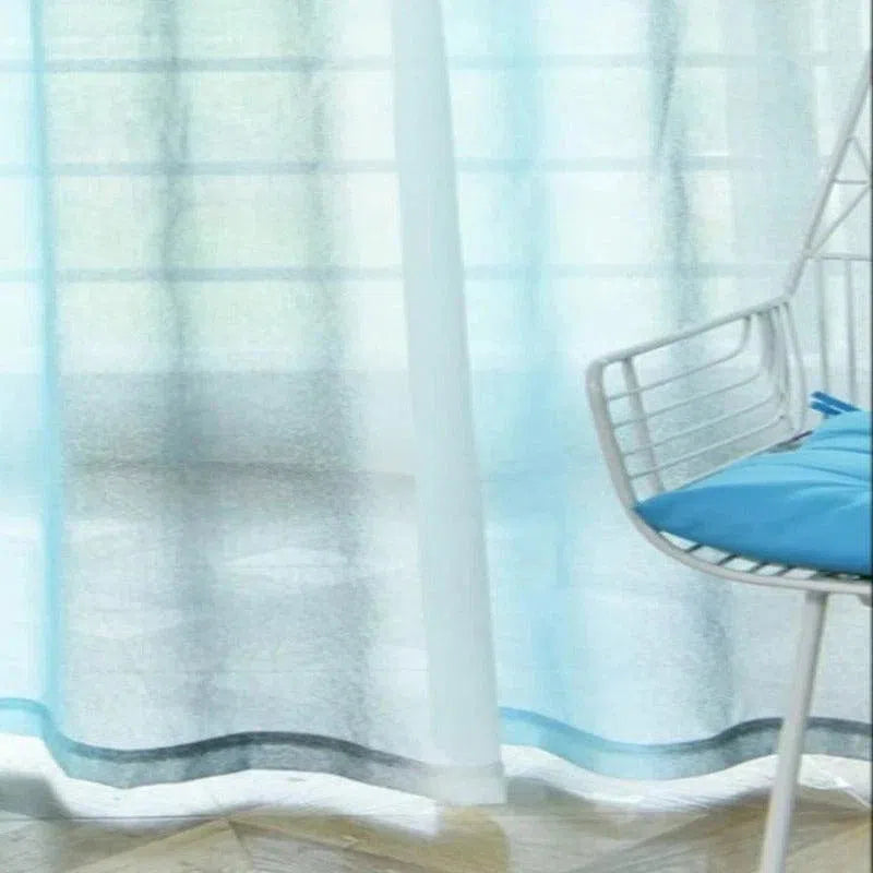 Voilage bleu transparent laissant passer la lumière, idéal pour un salon moderne. Ajoute une touche de fraîcheur à la décoration intérieure, avec une chaise blanche et coussin bleu pour un style épuré et contemporain. Accessoire parfait pour créer une ambiance lumineuse et aérée.