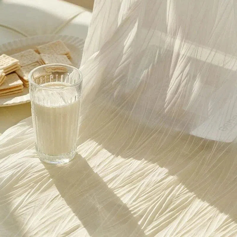 Verre de lait frais posé sur une table illuminée par le soleil, accompagné de biscuits sur une assiette, créant une ambiance douce et apaisante parfaite pour un petit-déjeuner ou une pause goûter, mettant en avant la lumière naturelle et les ombres délicates.