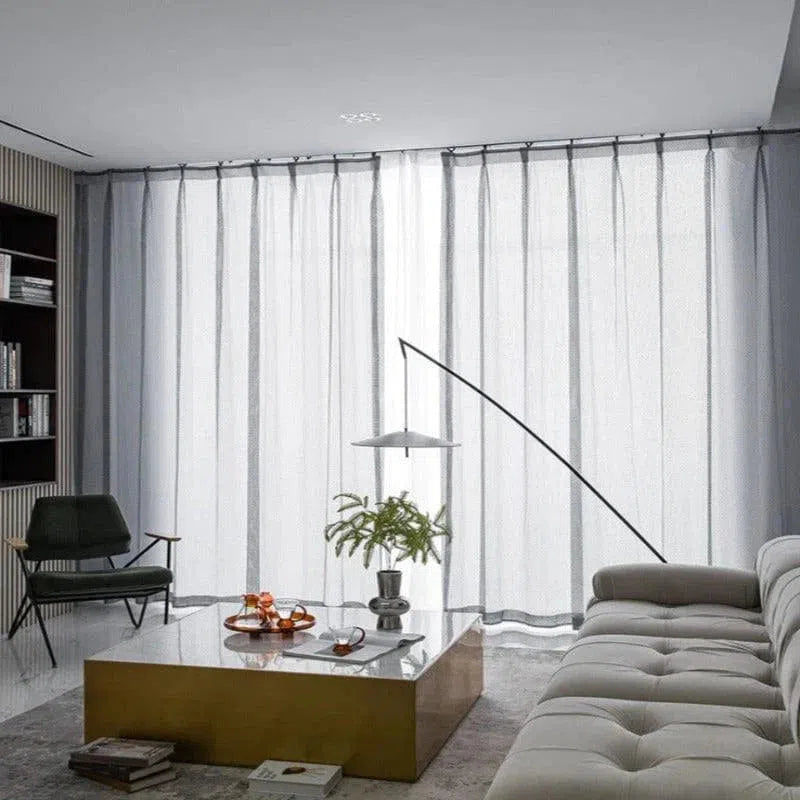 Rideaux occultants modernes dans un salon élégant avec un canapé contemporain, un fauteuil design et une table basse rectangulaire, offrant une ambiance chaleureuse et sophistiquée. Parfaits pour ajouter une touche déco tout en préservant l'intimité de la pièce.
