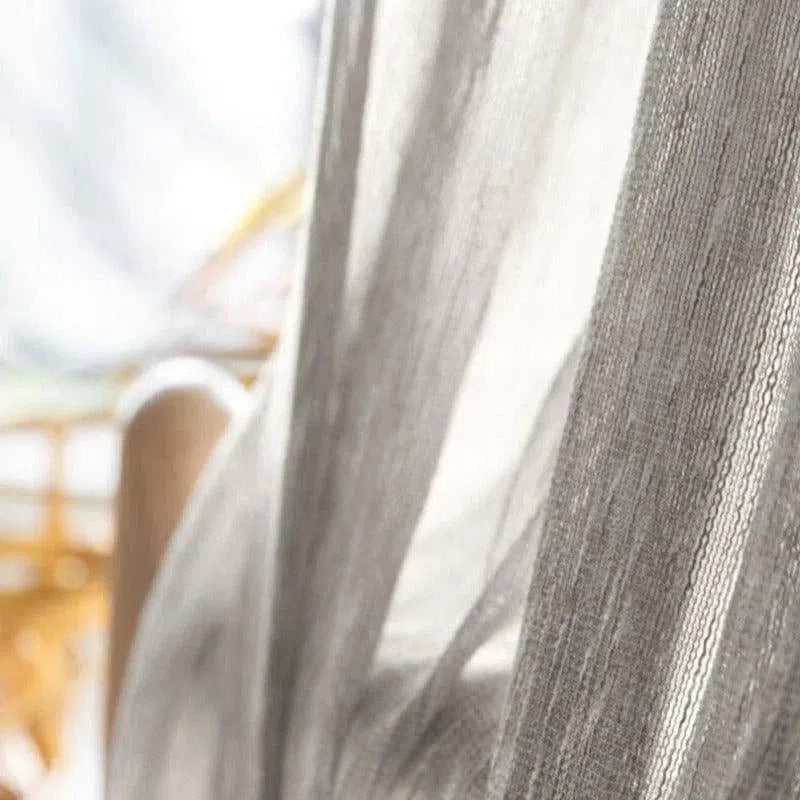 Voilage élégant translucide gris, idéal pour tamiser la lumière et apporter une ambiance douce et apaisante à votre intérieur. Parfait pour décorer les fenêtres du salon ou de la chambre avec style. Design moderne et raffiné, s'intégrant facilement dans divers styles de décoration d'intérieur.