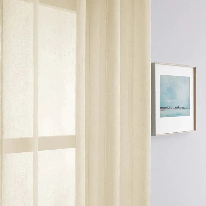 Rideau translucide élégant suspendu dans un intérieur moderne, laissant entrer une douce lumière naturelle. L'arrière-plan présente une œuvre d'art encadrée, soulignant la décoration murale contemporaine. Idéal pour ajouter une touche de légèreté et de sophistication à votre pièce. Les rideaux permettent d'améliorer l'esthétique tout en offrant une luminosité agréable.