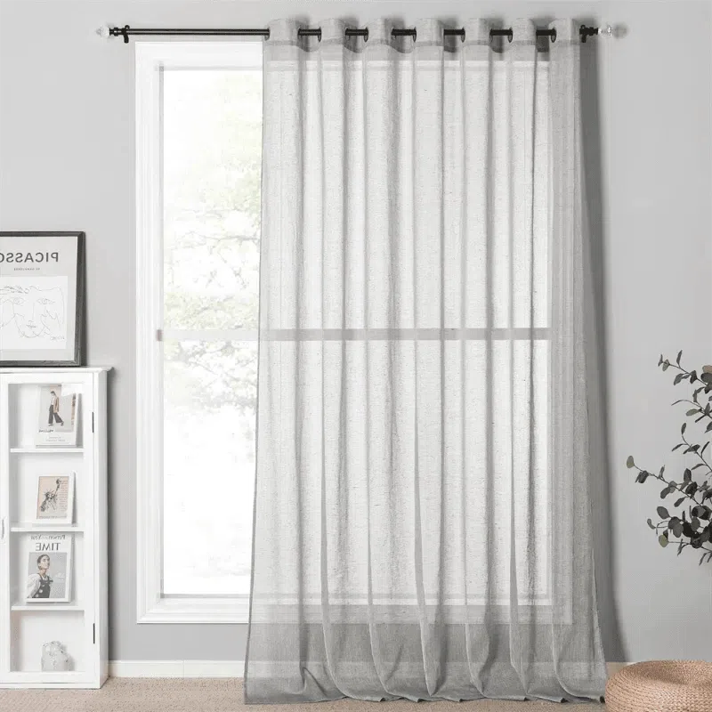 Rideau transparent pour salon moderne, suspendu à une tringle noire, laissant entrer la lumière naturelle. Idéal pour ajouter une touche élégante à toute fenêtre. Design simple et épuré s'intégrant facilement à divers styles de décoration intérieure.