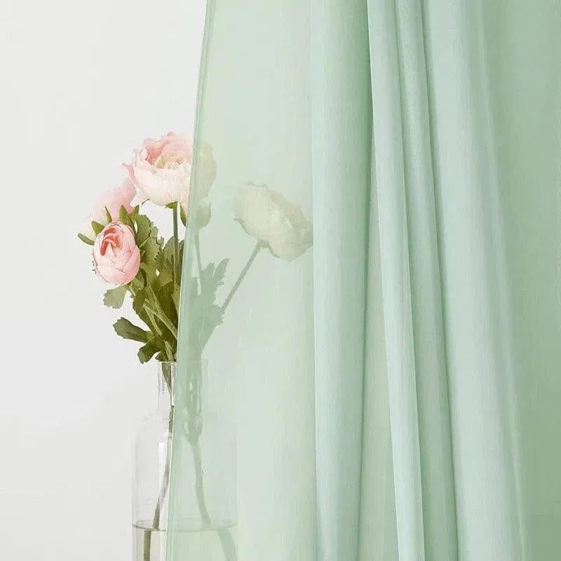 Rideau vert pastel élégant pour salon, offrant une ambiance lumineuse et apaisante. Idéal pour décorer une fenêtre avec style, mettant subtilement en valeur les arrangements floraux grâce à sa légèreté et transparence. Accessoire de décoration intérieure moderne, parfait pour une atmosphère sereine et rafraîchissante.